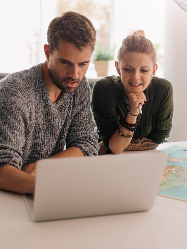 Young couple exploring the world on laptop computer.